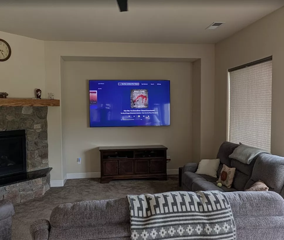 A large TV mounted level in a living-room wall niche with no cables showing