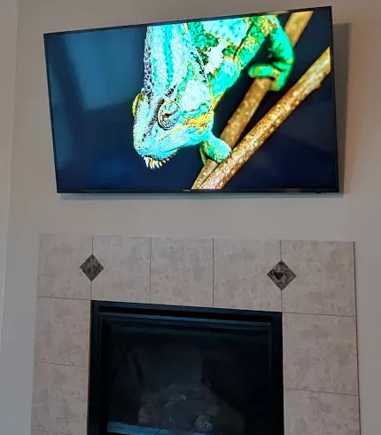 TV mounted above a tiled fireplace surround
